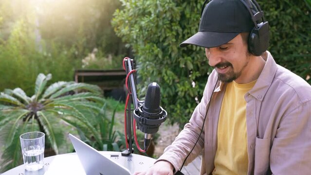 Young man recording radio podcast talking during live stream session outdoor. High quality 4k footage