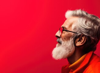 Portrait of a stylish senior man in red jacket and sunglasses on a red background. Men's beauty, fashion