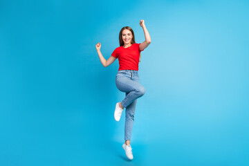 Fototapeta na wymiar Full length photo of positive glad girl dressed stylish clothes raise hands yes good news isolated on blue color background
