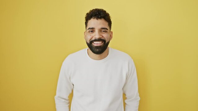 Young man standing winking looking at the camera with sexy expression, cheerful and happy face. over isolated yellow background