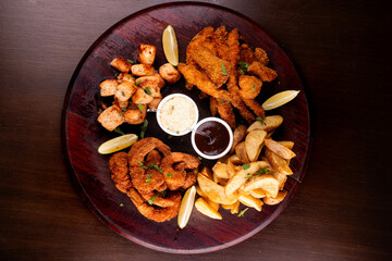 portion of seafood with breaded fish and shrimp and grilled salmon with fries top view