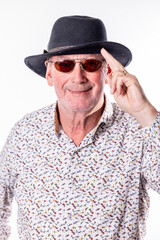 This engaging image features a senior man with a confident smile, tipping his fedora hat in a...