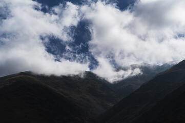 mountain peaks in fog against the sky with clouds in autumn