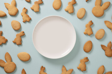 Easter cookies shaped of bunny on blue background. View from above. Festive food and kids snacks....