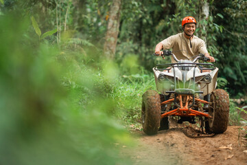asian man smiling brightly while riding the atv to spend holidays © Odua Images