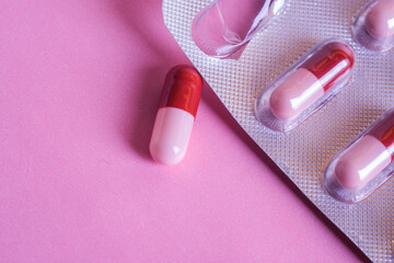 Medical medicine, Top view of pill removed from blister pack on pink background. Close up, copy...