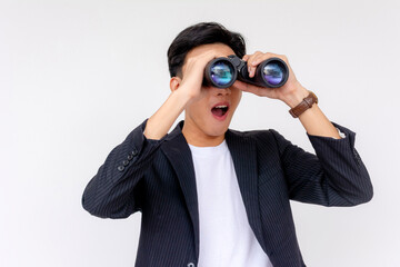A cheerful young Asian man with a surprised expression while using the binoculars, isolated on a white background.