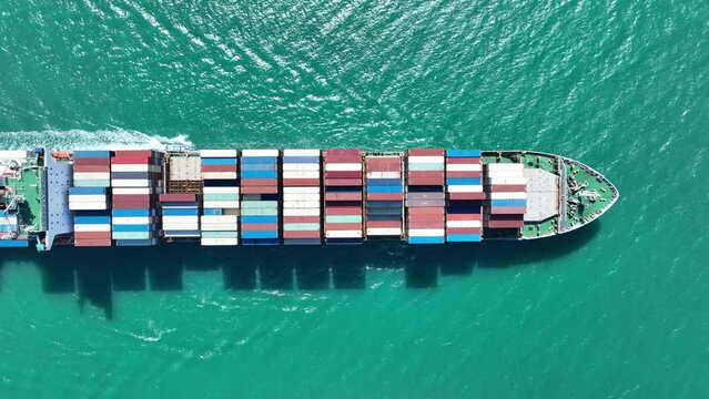 Aerial view of Cargo Container Ship at sunrise. container ship running out of cargo shipyard sea port. export shipping industry freight and transportation logistics concept. commercial shipping by sea