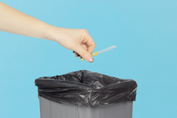 throw the pipette into the trash, nasal pipette in hand in front of the trash can, medical...