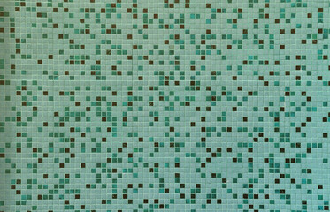 The texture of the wall, decorated with a mosaic of various small square tiles. Abstract pattern of ceramic tiles on the wall