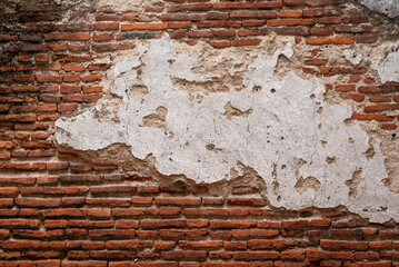 Old brick wall with large piece of stucco in the middle