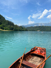 Fototapeta na wymiar Boat in the blue clear water and bright sky summer at the Lake Bled, Slovenia
