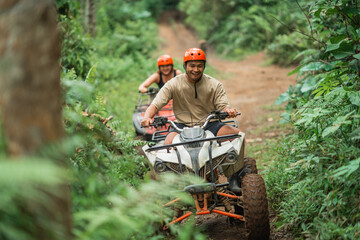 happy asian couple enjoy their trip riding the atv through the amusement park © Odua Images