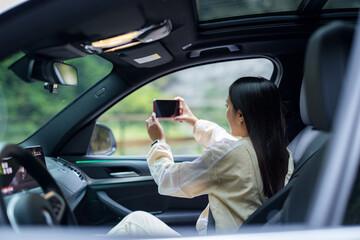 Travel woman use cellphone to take photo and sit inside car