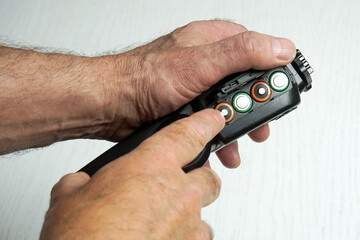 Male hands insert batteries into an electronic device.