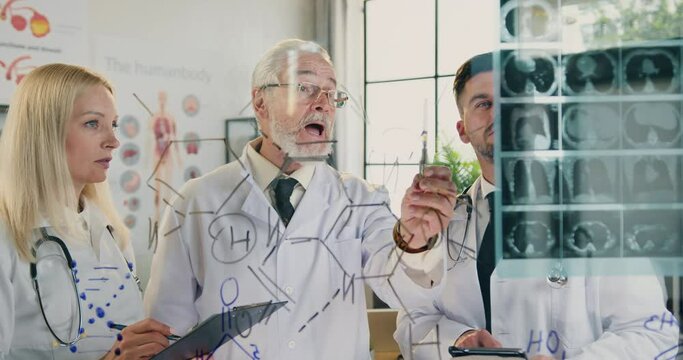 Man doctor holding medical council together with his male and woman subordinates when studying results of patient's x-ray scan in medical lab