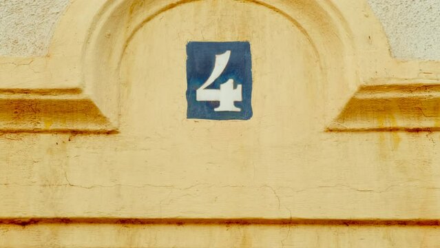 Number 4 (four) affixed to the exterior of a building, with an elegant, vintage and traditional appearance