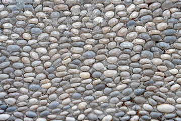 Neatly laid out pebbles on the sidewalk.