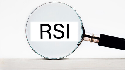 RSI Relative Strength Index lettering on through a magnifying glass on a light background