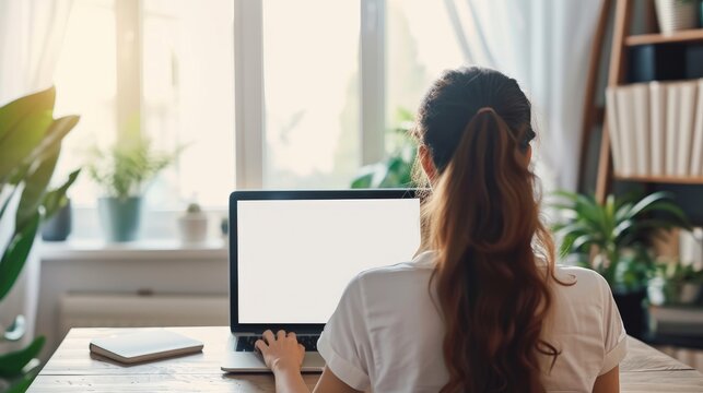 women using laptop computer working at home with blank white desktop screen.   