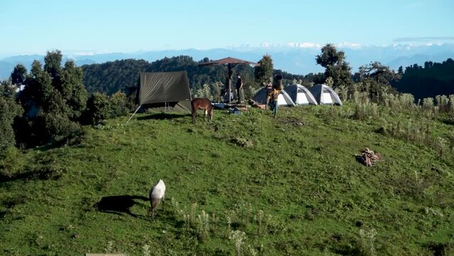 A wide angle shot of Camping in the hills of Himalayan region of Uttarakhand, India with visible Gomukh Glacier peaks in the background.
