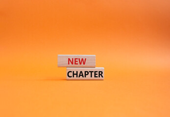 New Chapter symbol. Concept word New Chapter on wooden blocks. Beautiful orange background....