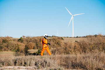 Unrecognizable technician walking against wind turbine in daylight