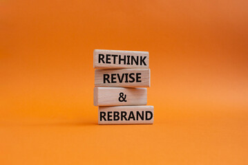 Rethink Revise and Rebrand symbol. Wooden blocks with words Rethink Revise and Rebrand. Beautiful orange background. Business and Rethink Revise and Rebrand concept. Copy space.