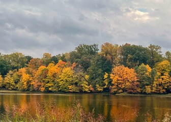 Still lake water reflecting the autumn color of the tree leaves lining the shoreline
