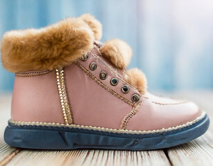 Pink leather warm child boots with fluffy fur, shoelaces and zipper on light wooden floor background. Closeup. Side front view. Empty place for text.2 - Copy.jpg