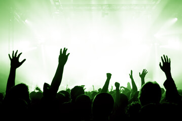Crowd cheering and watching a band on stage, blurred motion, shallow DOF.