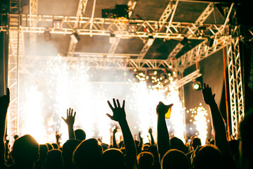 Crowd cheering and watching a band on stage, blurred motion, shallow DOF.