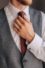 A man wears a bow tie. Hands close up. Man's clothes