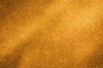 Close-Up Texture of Sparkling Gold Glitter Surface Under Bright Illumination