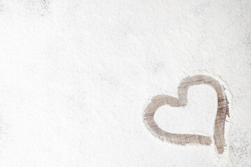 Heart silhouette made of flour on wooden background