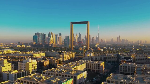 Aerial view of Dubai Frame at sunset, cityscape with modern buildings and skyscrapers in the city center and skyline of towers.