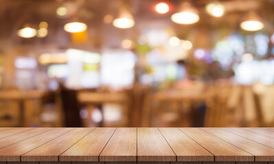 Empty wooden table top with lights bokeh on blur restaurant background.