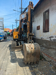 Fototapeta na wymiar an yellow excavator on the side of the street