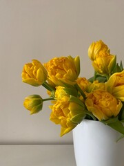 Elevate your decor with 'Sunny Elegance' – a radiant bouquet of yellow tulips in a chic white vase against a pristine white backdrop. Timeless sophistication and joy.
