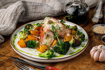 Baked chicken breast with baked potatoes and broccoli on a white plate