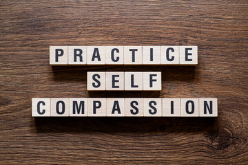 Practice self compassion - word concept on building blocks, text