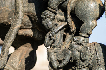 Fototapeta na wymiar Detail of a beautiful sculpture of a figure attacked by animals at the Chennakeshava temple complex in Belur, Karnataka.