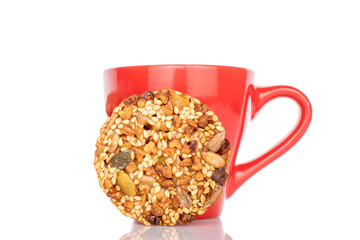 One sweet Thaler cookie with red ceramic cup, macro, isolated on white background.