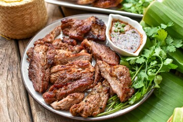 Grilled pork  and chili sauce with vegetables, top view food , banana leaf background,thai food