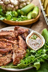 Grilled pork with wings  and chili sauce with vegetables, top view food , banana leaf and blur background,thai food