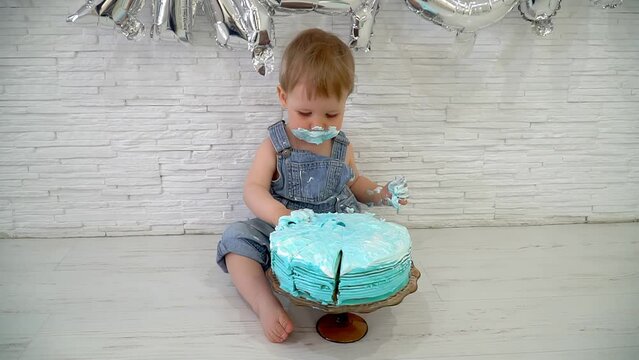 one-year-old boy eating cake on his first birthday, happy infant baby celebrating his first birthday. concept of children's birthday.