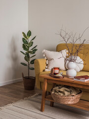 The cozy interior of the living room is a wooden bench with a vase and decor next to the sofa