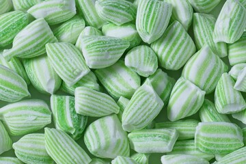 Close up top view of a pile of green and white striped mint candy - Powered by Adobe