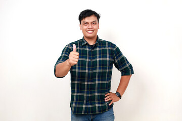 Fototapeta premium Young asian handsome man wearing casual shirt over white background success sign doing positive gesture with hand, thumbs up smiling and happy. Cheerful expression and winner