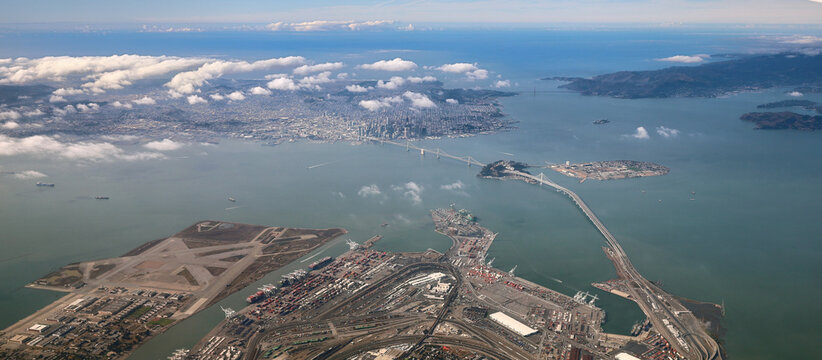 Aerial View of the San Francisco Bay Area - Looking west from Oakland and Alameda island over the bay bridge towards downtown San Francisco. In the far distance, one can see the Golden Gate Bridge.